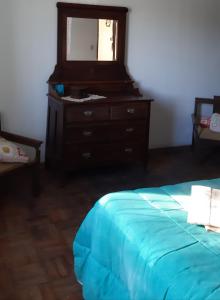 um quarto com uma cama e uma cómoda com um espelho em Apartamento no centro em São Lourenço