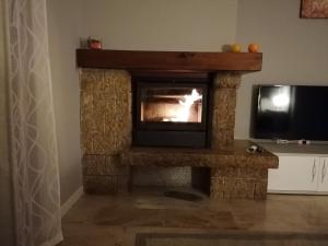 a living room with a stone fireplace with a television at Italaforesteria in Lavone