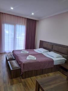 Hotel Ramaz Paliani في ميستيا: غرفة نوم بسرير كبير ونافذة