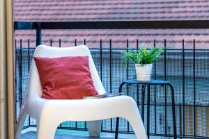 una silla blanca sentada en un balcón con una almohada roja en Quick Home Agatha Apt, en Santhià