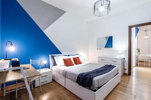Dormitorio azul y blanco con cama y escritorio en Quick Home Agatha Apt, en Santhià