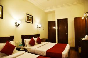 a hotel room with two beds with red pillows at Hotel Sapphire Opposite Golden Temple in Amritsar