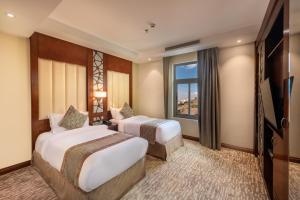 um quarto de hotel com duas camas e uma janela em Sarwat Park Hotel em Abha