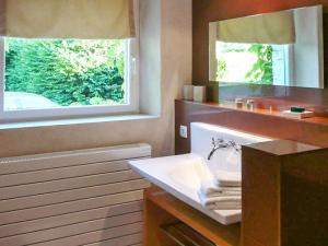 een badkamer met een wastafel, een spiegel en een raam bij Maison de 4 chambres avec piscine privee jardin clos et wifi a Bellon in Bellon