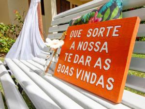 um sinal sentado em cima de um banco branco em Pousada Hibiscus em Porto de Galinhas