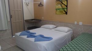Un dormitorio con una cama con toallas azules. en Duas Praias Hotel Pousada, en Guarapari