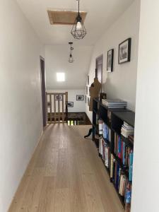 a hallway with a book shelf filled with books at Les Chambres De Napoleon in Lannédern