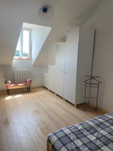 a bedroom with white cabinets and a bed and a window at Les Chambres De Napoleon in Lannédern