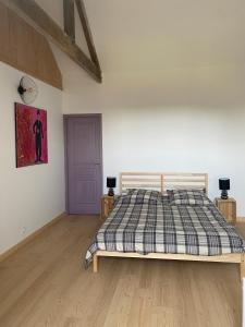 una camera con un letto e una porta viola di Les Chambres De Napoleon a Lannédern