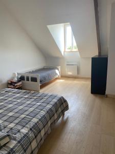 1 dormitorio en el ático con cama y ventana en Les Chambres De Napoleon, en Lannédern