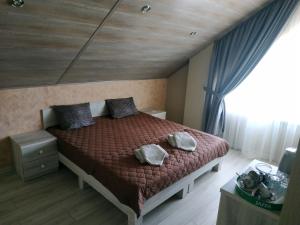 a bedroom with a bed with a red comforter and a window at Sanpic in Sanzhiyka