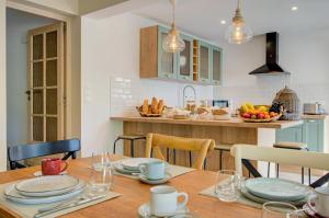 a kitchen with a wooden table with plates on it at Domaine Le Courti - Adult only in Le Barcarès