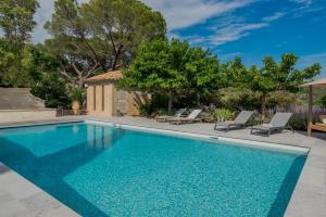 einen Pool mit zwei Liegestühlen und ein Haus in der Unterkunft LOU CALEN in Cotignac