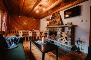 a living room with a fireplace and a table at Chalupa Lieskovec in Tatranska Strba