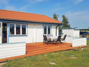 una terraza de madera con mesa y sillas en una casa en 6 person holiday home in R dby, en Kramnitse