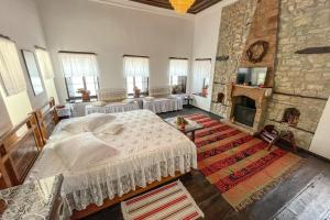 1 dormitorio con 1 cama grande y chimenea en Bujtina Kodiket Guesthouse en Berat