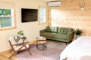 a bedroom with a green couch and a chair at The Rex in Greentown