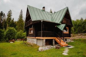 una pequeña casa con techo verde en un campo en Chalupa Lieskovec en Tatranska Strba