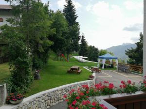フォルガリーアにあるHotel Trentinoのピクニックテーブルと遊び場のある公園