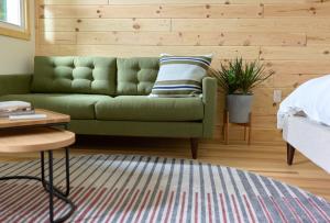 a living room with a green couch in a bedroom at The Rex in Greentown