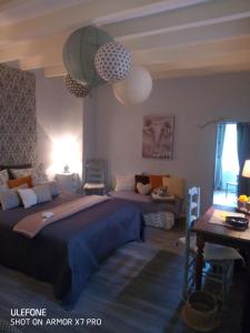 um quarto com uma cama grande e um sofá em Cœur de vigne à Colombier 24560 em Issigeac