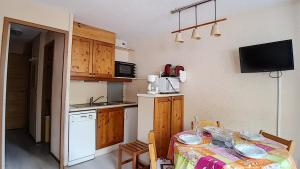 una pequeña cocina con mesa y mantel. en travelski home classic - Résidence Boedette, en Les Menuires 5 fotos más