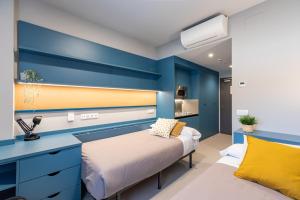 1 dormitorio con cama y pared azul en Residencia Universitaria Resa San Mamés, en Bilbao