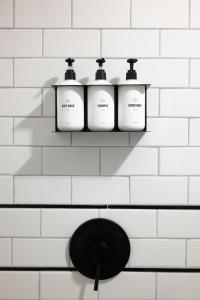 a shelf with four bottles on a white tiled wall at The Rex in Greentown