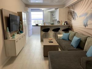 a living room with a couch and a tv and a kitchen at Apartament delmar (Ștefan building resort) in Mamaia Nord