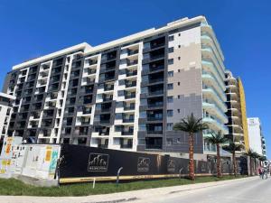 a tall building with palm trees in front of it at Apartament delmar (Ștefan building resort) in Mamaia Nord