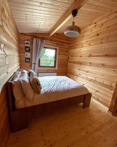 um quarto com uma cama num chalé de madeira em Southern County Resort em Sheean