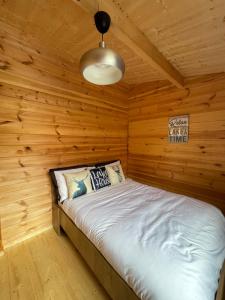 1 dormitorio con 1 cama en una cabaña de madera en Southern County Resort, en Sheean