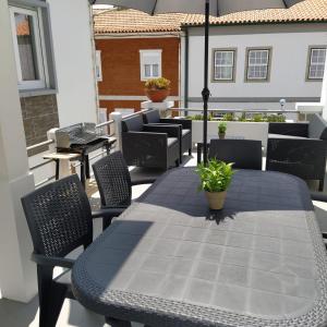 a black table and chairs on a balcony with a table and chairs at Portela House - T3 Residential home 50 meters from the beach in Vila Praia de Âncora