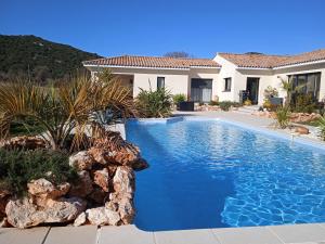 a swimming pool in front of a house at Le Mas De L'Escale in Viols-le-Fort