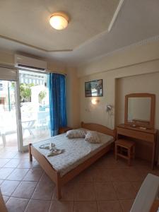 a bedroom with a bed and a mirror and a table at Villa Cosmos Inn in Olympic Beach