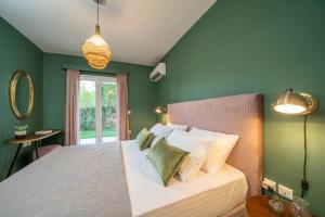 sypialnia z zielonymi ścianami i łóżkiem z poduszkami w obiekcie Central & Elegant Suite with private garden w mieście Argostoli