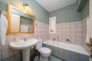 łazienka z umywalką, toaletą i wanną w obiekcie Central & Elegant Suite with private garden w mieście Argostoli