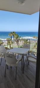 einen Tisch und Stühle auf einem Balkon mit Meerblick in der Unterkunft Estudio SHEILA in Torrox Costa