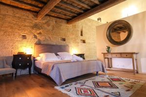 a bedroom with a large bed and a mirror at La Maison D'Aimé - Demeure de caractère du XIIe siècle in Saint-Quentin-la-Poterie +38 photos