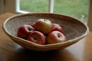 a basket of apples sitting on a table at Field Cottage Bed and Continental Breakfast in East Harling