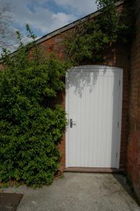 a white garage door in a brick building at Field Cottage Bed and Continental Breakfast in East Harling