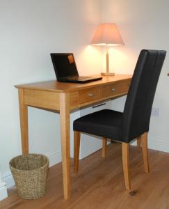 a desk with a laptop computer on top of it at Field Cottage Bed and Continental Breakfast in East Harling