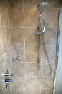 a shower with a shower head in a bathroom at Field Cottage Bed and Continental Breakfast in East Harling