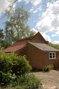 a brick house with a window and a roof at Field Cottage Bed and Continental Breakfast in East Harling