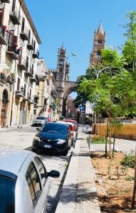 uma rua com carros estacionados na berma da estrada em A due passi dalla cattedrale em Palermo