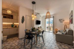 kuchnia i salon ze stołem i krzesłami w obiekcie Casa Royale Appartamento Acqua w mieście Lierna