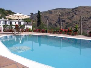 una gran piscina azul con una montaña en el fondo en CASASBLANCAS. Casa nr 5 en Alpujarra de la Sierra