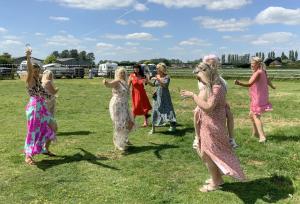 a group of women in dresses standing in a field at Glamping with Llamas in Wisbech