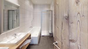 a bathroom with two sinks and a tub and a shower at A Casa Saphir Appartement-Hotel in Sölden +105 photos