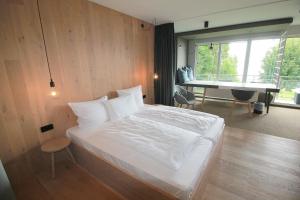 a bedroom with a bed and a desk and a piano at Junior-Suite "Bellavista" mit Seeblick in Ascheberg